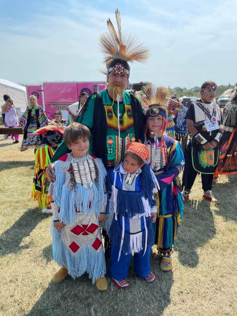 Photo of Mikey and family at a Powwow event
