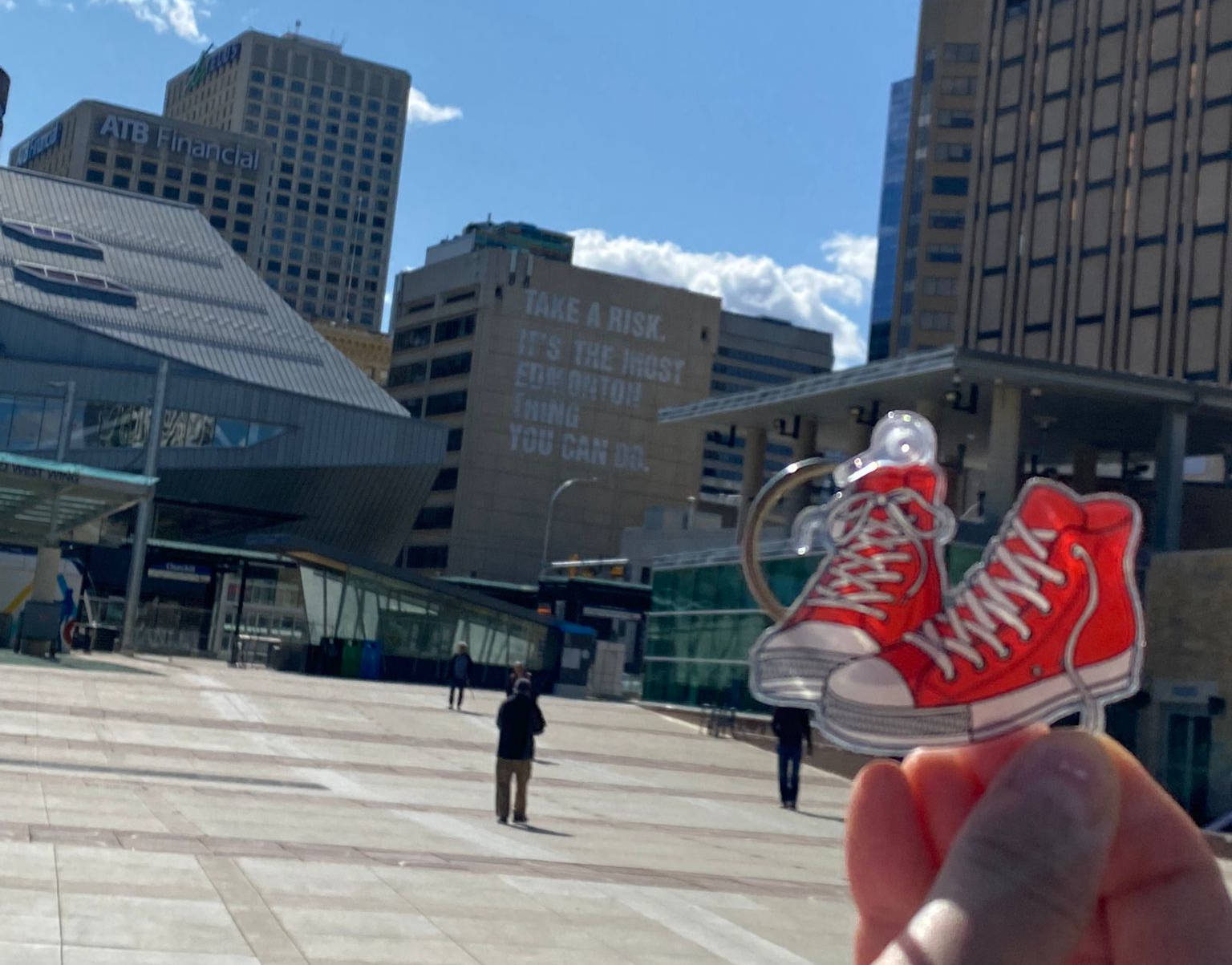 Red shoes held up against the background of Churchill Square during 2022's Red Shoe Walk.